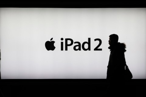 A man walks past an iPad 2 advertisement in Shanghai