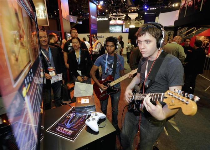 E3 attendees Dylan Barrie and Sandeep Shekar try out the new BandFuse Rock Legends