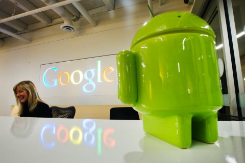 A Google Android figurine sits on the welcome desk as employee McNeilly smiles at the new Google office in Toronto
