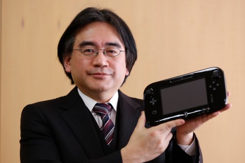 Nintendo Co's President Iwata poses with company's Wii U gaming controller at company headquarters after an interview with Reuters in Kyoto